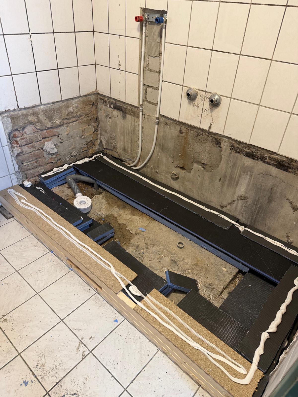 Badkamer renovatie tijdens werkzaamheden, open badkuip en betegelde muren
