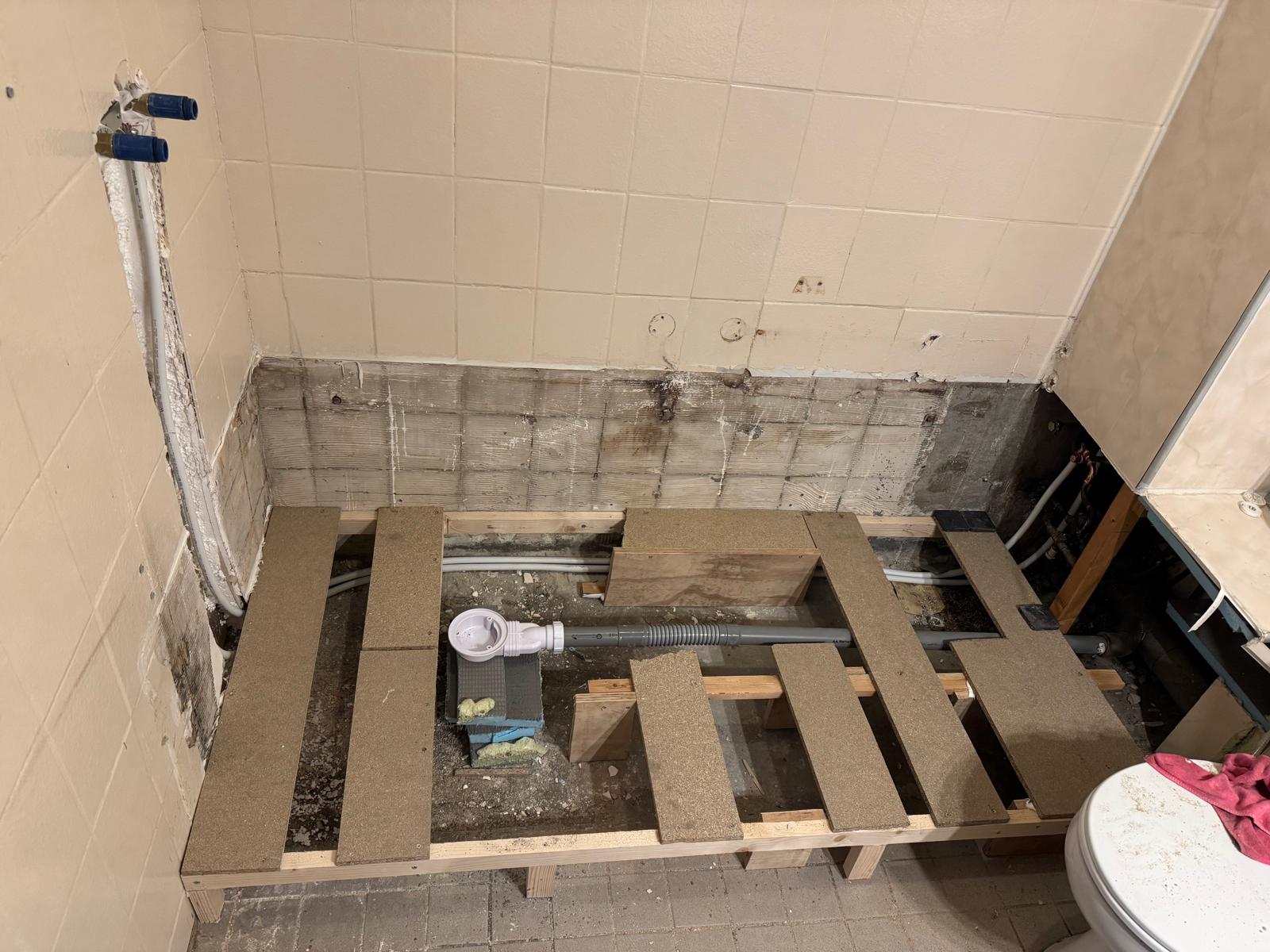 Badkamer renovatie in uitvoering, vloer opengebroken voor nieuwe installatie