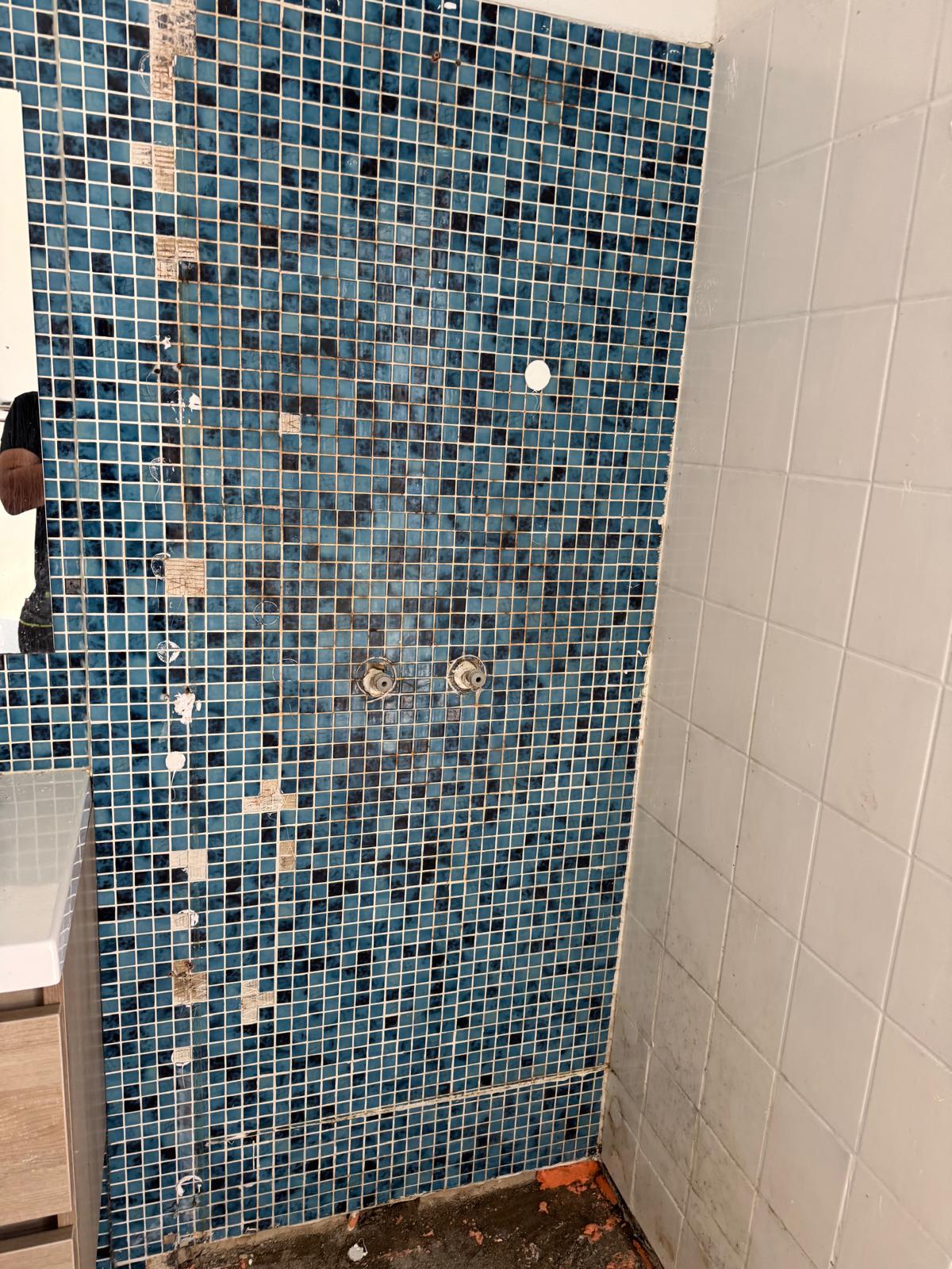 Blauwe mozaïek tegels op badkamer wand voor renovatie