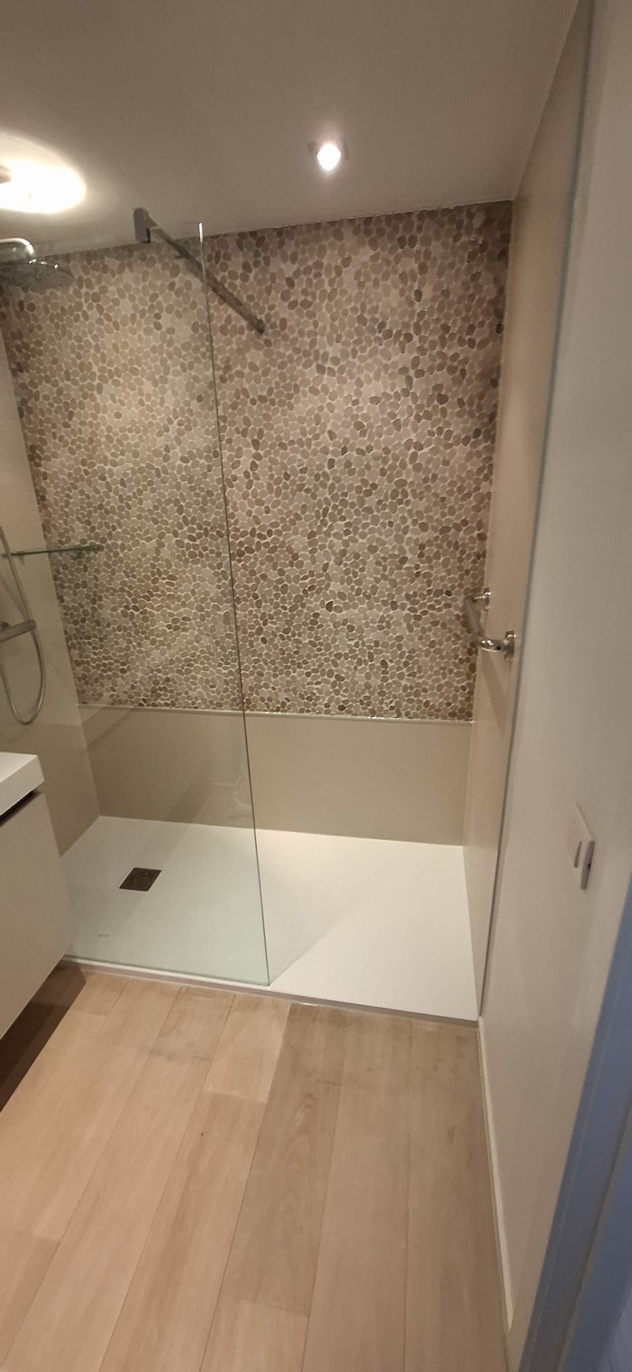 Douchecabine met glazen wand en kiezelsteen-look tegelwand