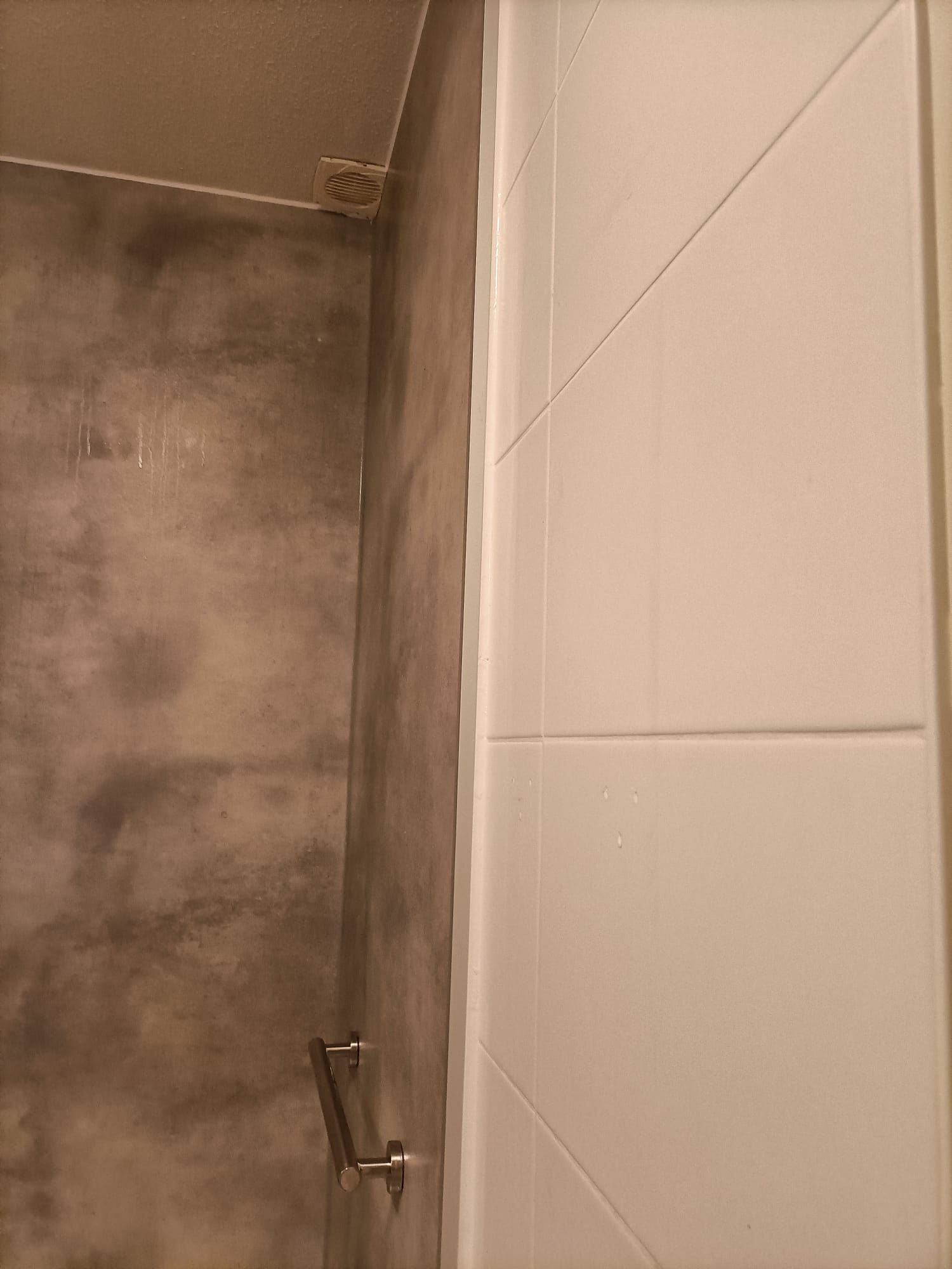 Douche met grijze wand en witte betegeling