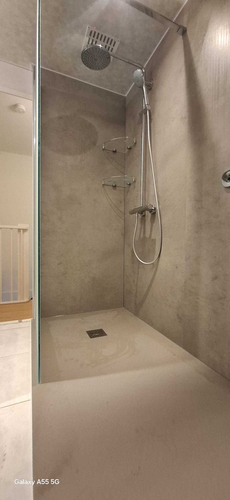 Douche met grijze betegeling en moderne douchekop
