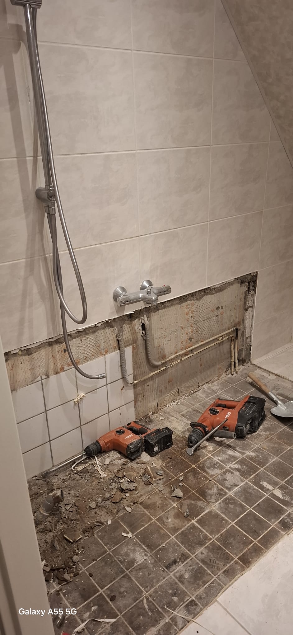 Sloopwerk badkamer met gereedschap en opengelegd leidingwerk