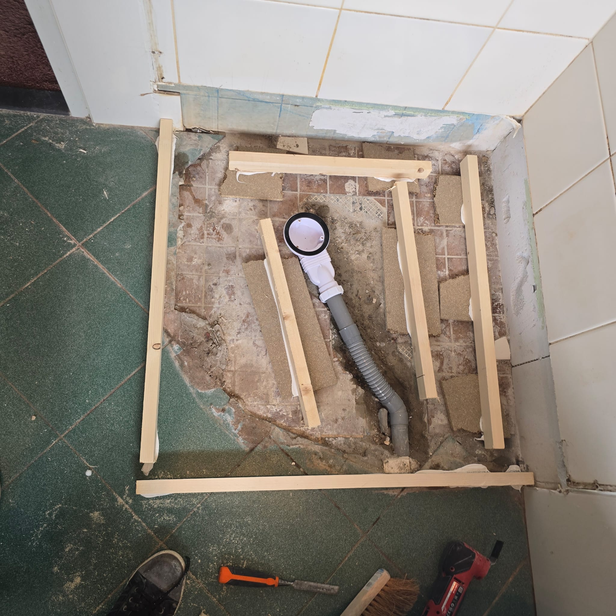Douchevloer renovatie met houten frame en afvoerbuis