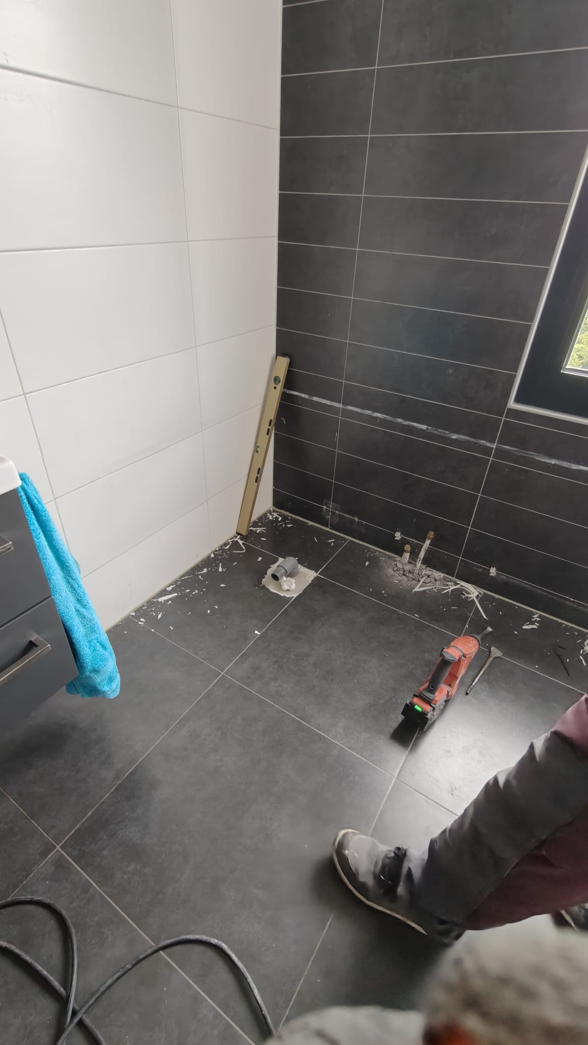 Tijdens badkamer renovatie, vloer en muur betegeld met grijs en wit
