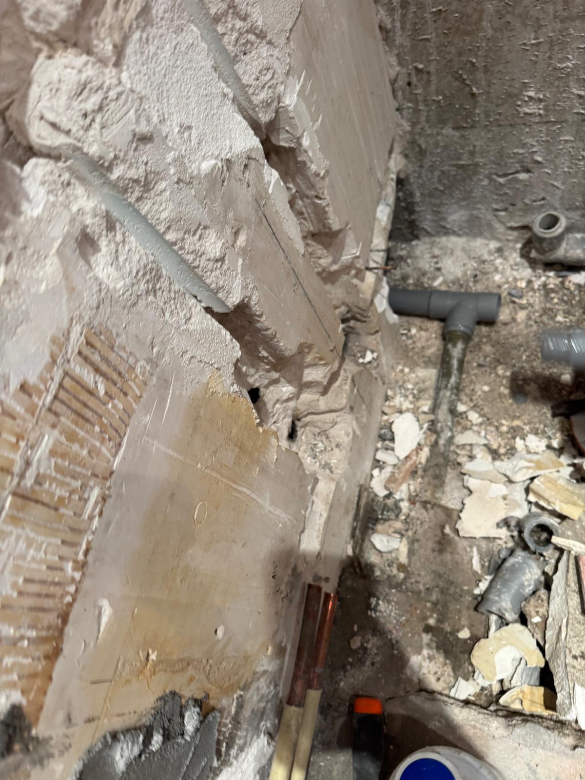 Sloopwerkzaamheden in badkamer met zicht op puin en bouwmaterialen