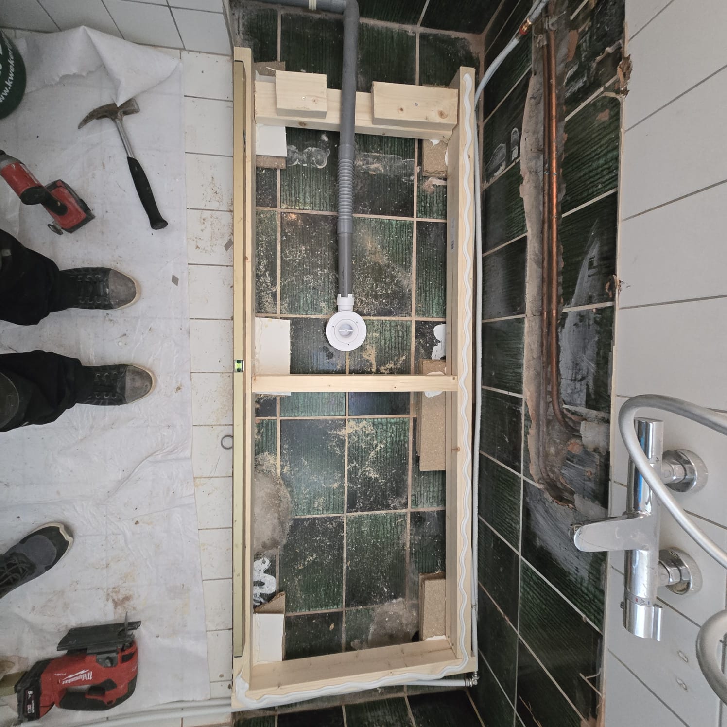 Badkamer renovatie in uitvoering, houten frame en gereedschap zichtbaar