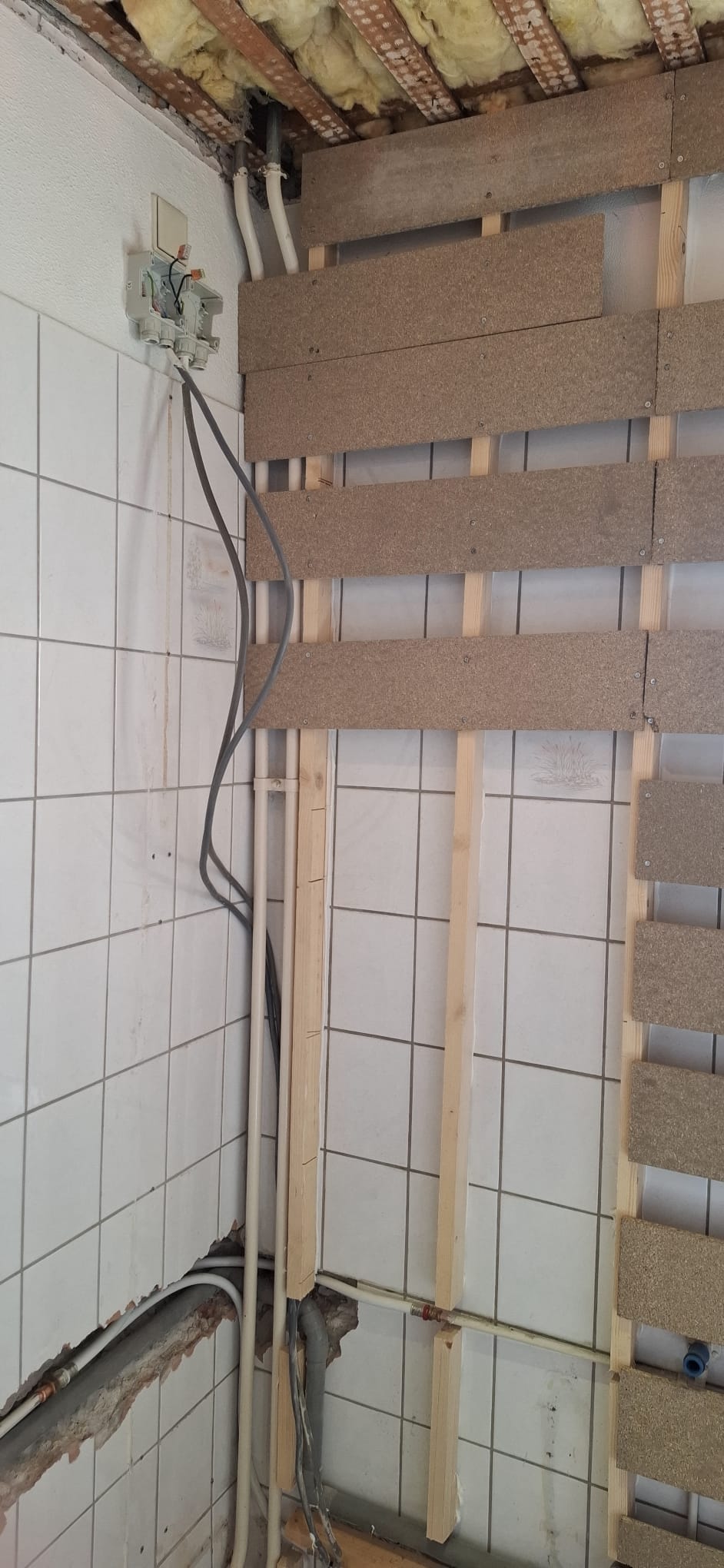 Badkamer renovatie in uitvoering met zicht op de betegelde wand en houten constructie