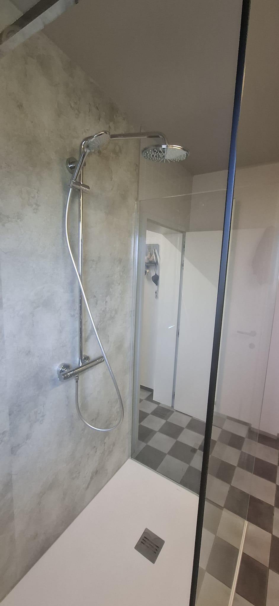 Douchecabine met glazen wand, chroom douchekraan en grijze wandtegels
